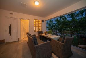 a patio with chairs and a table and a balcony at Apartman Karla in Solin