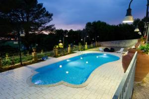 una piccola piscina in un cortile posteriore di notte di ViverE' Resort a Presicce