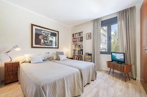 a bedroom with two beds and a television in it at Apartment Vora Dor in Port de Pollensa