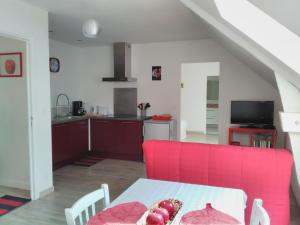 sala de estar con mesa y cocina en La Pomme Rouge, en Trévières