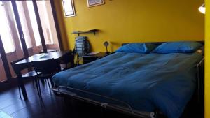 una camera con letto blu, scrivania e finestra di Varigotti #subitoalmare a Varigotti