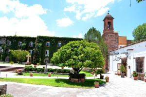 budynek z drzewem i wieżą zegarową w obiekcie Posada de la Aldea w mieście San Miguel de Allende