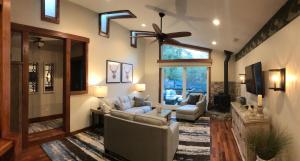 a living room with two couches and a ceiling fan at The Grand Idyllwild Lodge in Idyllwild
