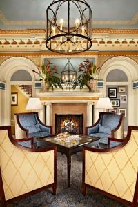 a living room with a table and a fireplace at Grande Colonial La Jolla in San Diego