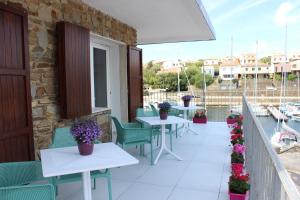 a patio with tables and chairs on a balcony at 103 Boutique Hotel Stintino in Stintino