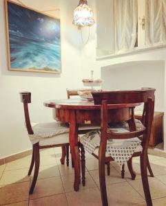 un tavolo in legno con 2 sedie e un tavolo con una scrivania di La Casetta a Matera