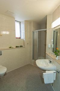 La salle de bains est pourvue d'un lavabo, de toilettes et d'une douche. dans l'établissement Hotel Stadt Löbau, à Löbau