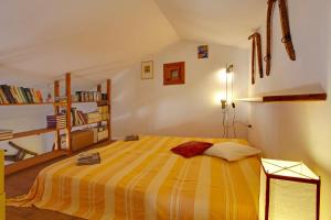 - une chambre dotée d'un lit avec une couverture rayée jaune et orange dans l'établissement Casa Vacanza Perla Bianca, à Castelluzzo