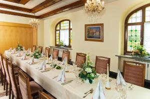 a conference room with a long table with flowers on it at Hotel Stadt Löbau in Löbau