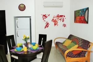 a dining room with a table and a couch at Maya Vacanze Playa Quinta B&B in Playa del Carmen