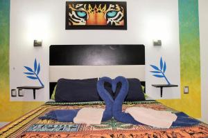 Un dormitorio con una cama con una cinta azul. en Maya Vacanze Playa Quinta B&B, en Playa del Carmen