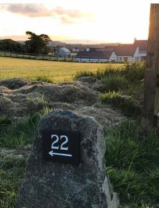 a sign on a rock in a field at Primrose Place Portrush in Portrush