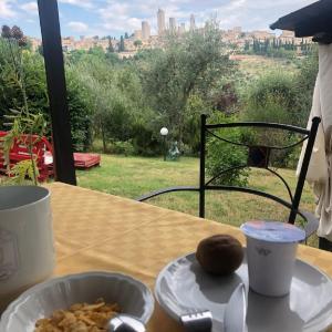 einen Tisch mit einem Teller Essen und einer Tasse Kaffee in der Unterkunft Antico Casolare in San Gimignano