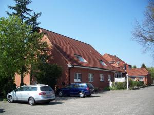 two cars parked in a parking lot in front of a building at Hotel Barmstedter Hof in Barmstedt