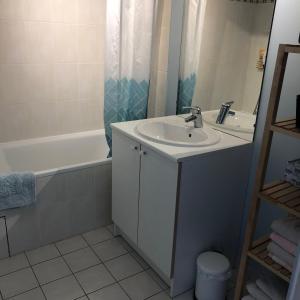 een badkamer met een wastafel en een bad bij La maison de Julie Albert in Albert
