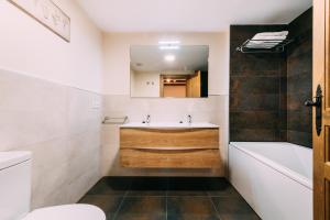 a bathroom with a sink and a tub and a toilet at Casa Rural Monte Perdido in Sarvisé