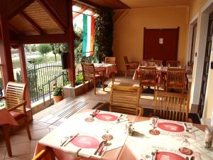 a restaurant with tables and chairs on a patio at Angela Panzió in Berettyóújfalu