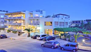 a parking lot with cars parked in front of a building at Falassarna Hotel in Chania