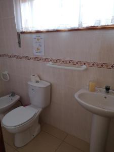 baño con aseo y lavabo y ventana en Prothea Home en Vila Chã