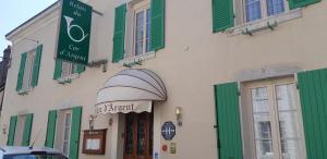 een gebouw met groene luiken en een bord erop bij Logis hôtel LE COR D'ARGENT in Argent-sur-Sauldre