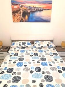 a bed with polka dot pillows and a painting on the wall at Casa Aurora in Polignano a Mare