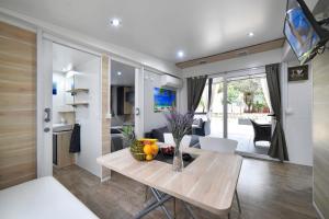a dining room and living room with a wooden table at Mobile Home MeeLi in Biograd na Moru