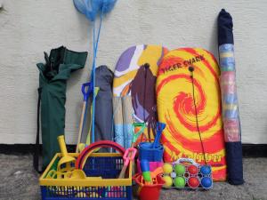 a bunch of umbrellas and other items next to a wall at 35 Gower Holiday Village in Reynoldston