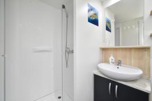 a white bathroom with a sink and a shower at Mobile Home MeeLi in Biograd na Moru +36 photos