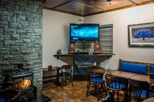 una sala da pranzo con camino e TV di The Village Inn a Killarney