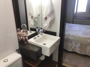 y baño con lavabo, aseo y espejo. en Confortável, bem localizado Apto Saint Peter, en Foz do Iguaçu