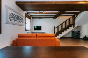 an orange couch in a living room with a staircase at Casa Rural Monte Perdido in Sarvisé