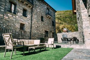 a patio with chairs and a couch in front of a building at Casa Rural Monte Perdido in Sarvisé