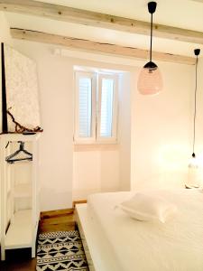 a bedroom with a white bed and a window at Familia in Selca