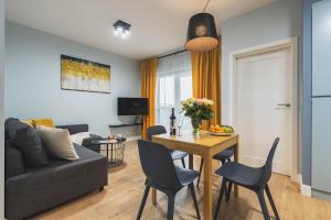 a living room with a table and a couch at Airport Okecie Wagonowa Serviced Apartments in Warsaw
