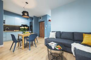 salon z kanapą i stołem oraz kuchnia w obiekcie Airport Okecie Wagonowa Serviced Apartments w Warszawie +8 zdjęć