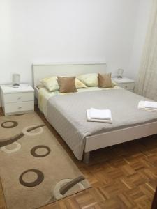 - une chambre avec un lit avec un tapis et 2 tables de nuit dans l'établissement Apartment Marija, à Primošten