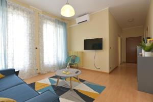 a living room with a blue couch and a table at Casa Dollu in Rivarolo Canavese