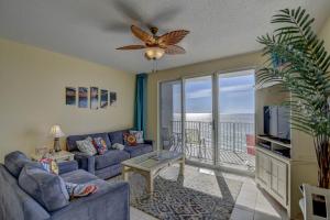 a living room with a couch and a tv and a balcony at Majestic Sun 913A Miramar Beach (Condo) in Destin