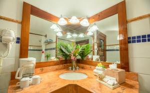 un bagno con un lavandino e un grande specchio di The Lodge At Uxmal a Uxmal