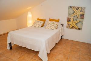 - un lit blanc avec des oreillers dans l'établissement Slowing Villas - Villa Oceano, à Vila Baleira