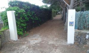 a gate in a fence next to a dirt road at Ustica Mari e Carlo Contrada Ogliastrello in Ustica