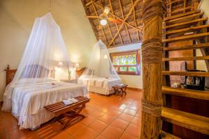 una camera con 2 letti e zanzariere di The Lodge At Uxmal a Uxmal