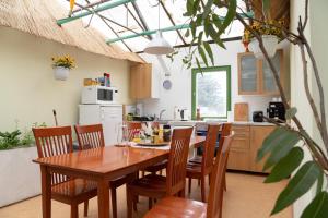 cocina con mesa de madera y sillas de madera en Rastlinky.sk Greenhouse Guestrooms, en Bratislava