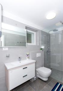 a bathroom with a toilet and a sink and a shower at Apartments West Coast in Split