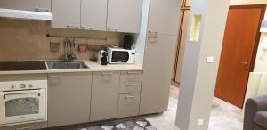 cocina con fregadero y microondas en Grattacielo Apartment, en Rapallo