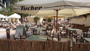 um restaurante ao ar livre com mesas e cadeiras e um guarda-sol em Apart-House Nürnberg em Nurembergue