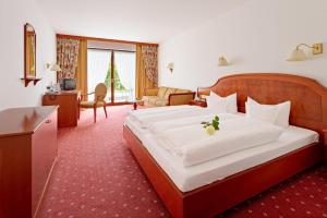 ein Hotelzimmer mit einem großen Bett und einem Wohnzimmer in der Unterkunft Hotel 3 Könige in Oberwolfach