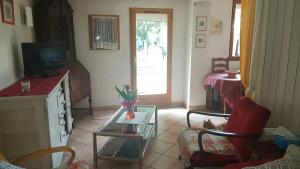 a living room with a tv and a table at LE ROSSIGNOL in Cranves-Sales