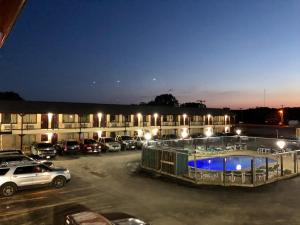 un aparcamiento frente a un edificio con piscina en Inn at Mexia, en Mexia