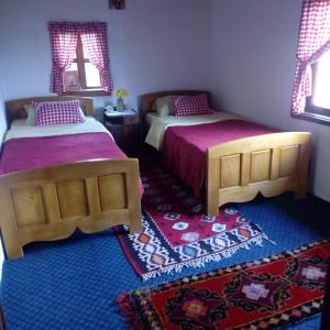 1 dormitorio con 2 camas y alfombra en Etno guest house Lalovic, en Tjentište
